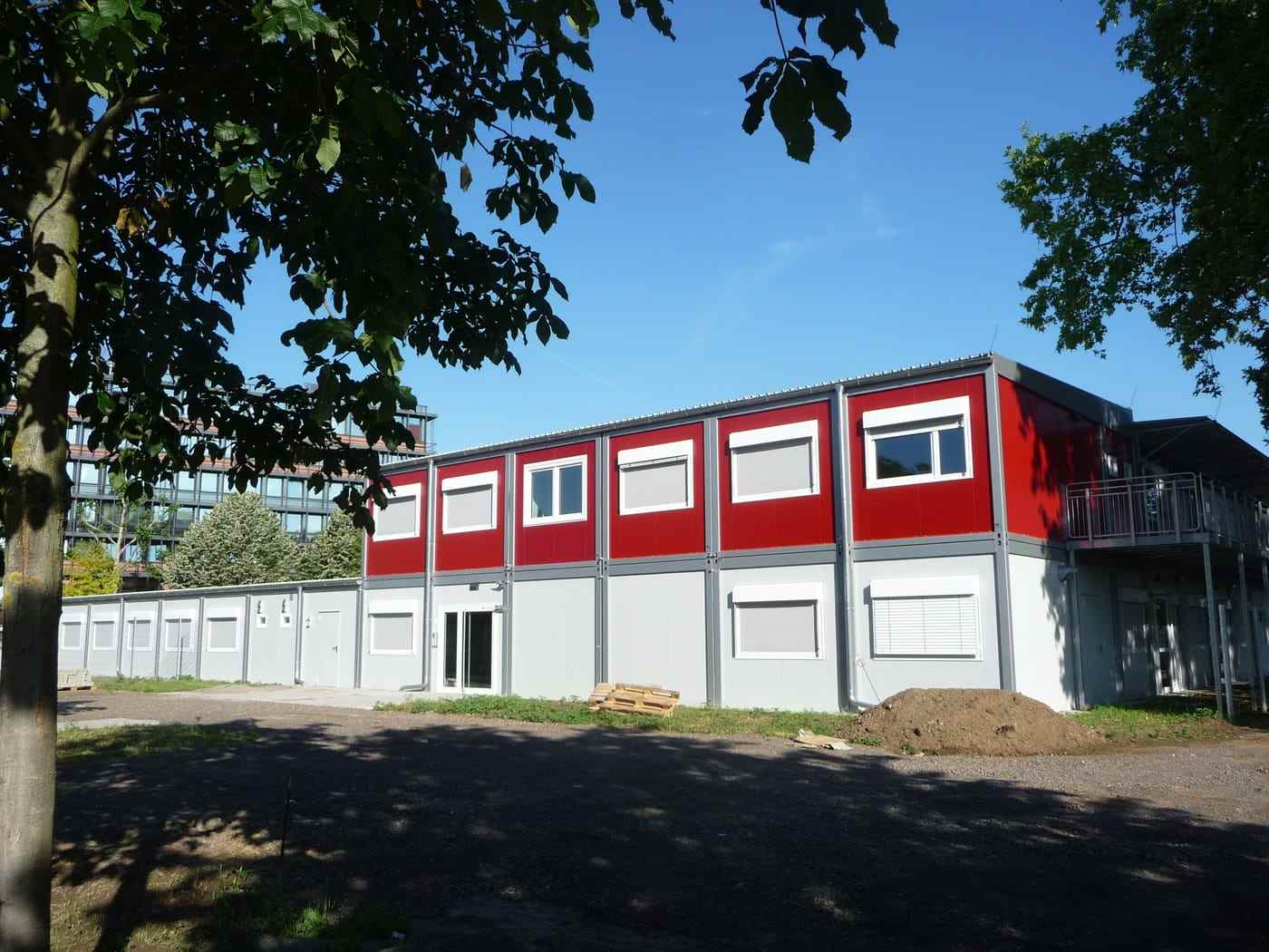 A two-storey modular teaching block in red and white cladding